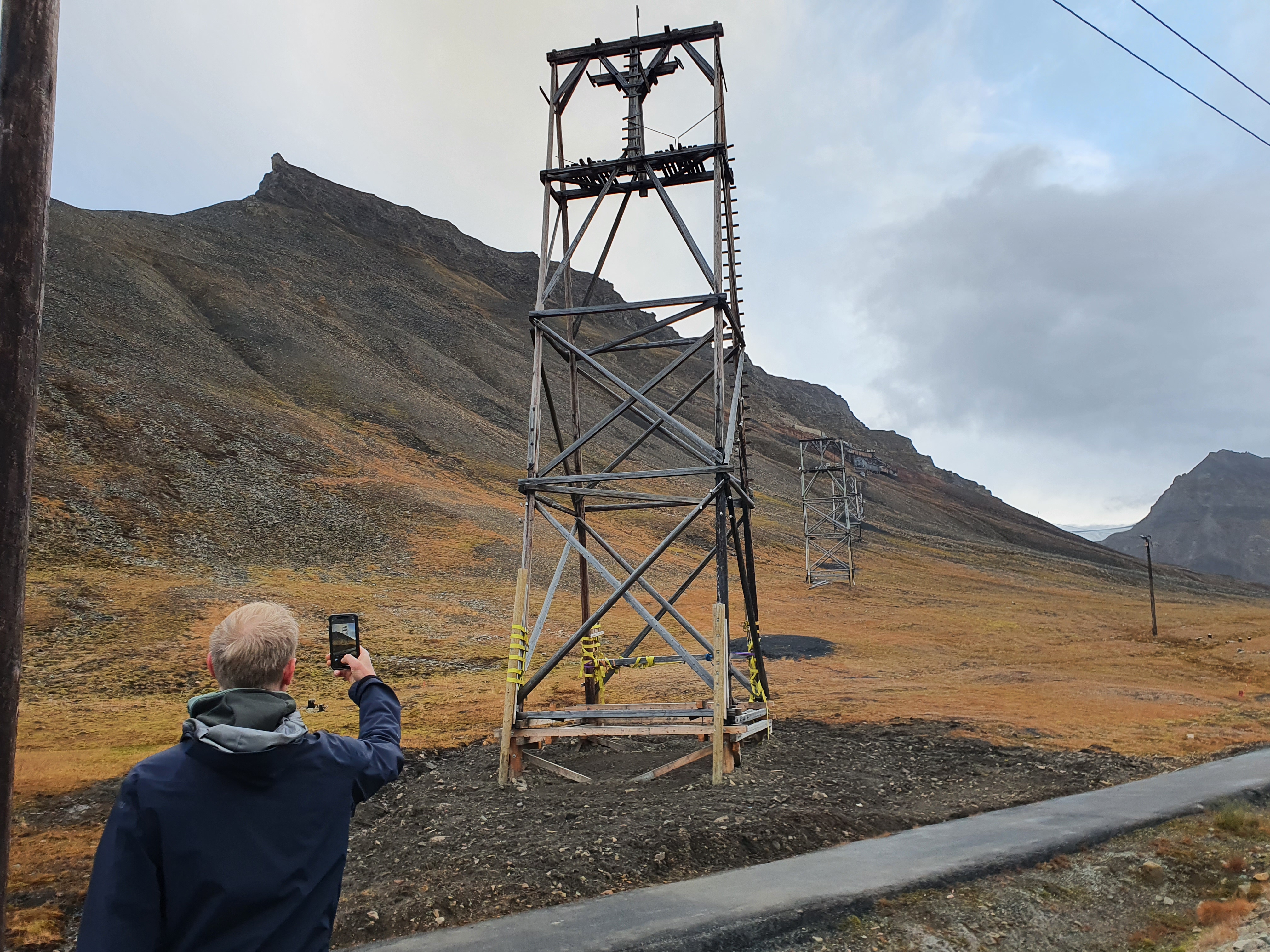 Mann fotograferer gamal mast med mobilen sin