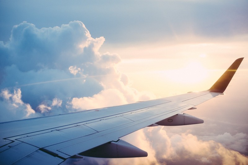 Aircraft wing in air, clouds and sunshine