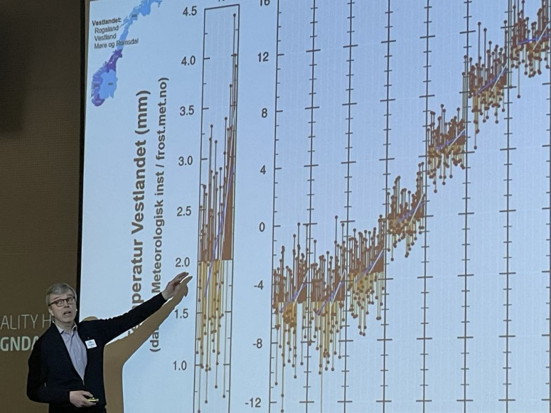Klimaforskar viser graf for publikum på konferanse