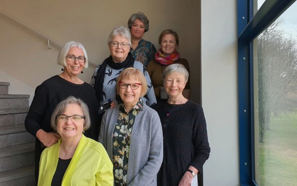 Ei gruppe kvinner i akademia står oppstilt og smiler