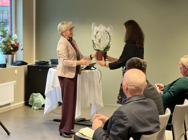 Liv Signe overrekker blomster til Anne Karin