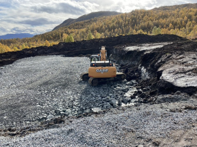 Gravemaskin i fjellandskap