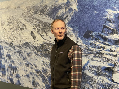 Forskar Halvor Dannevig fotografert framfor kart over Hodlekve