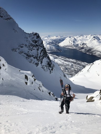 tindar med snø i nordnorsk landskap, skigåar ber skia sine oppover