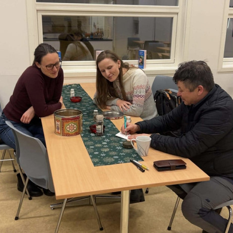 tre personar ser på eit ark der ein forklarer og teiknar